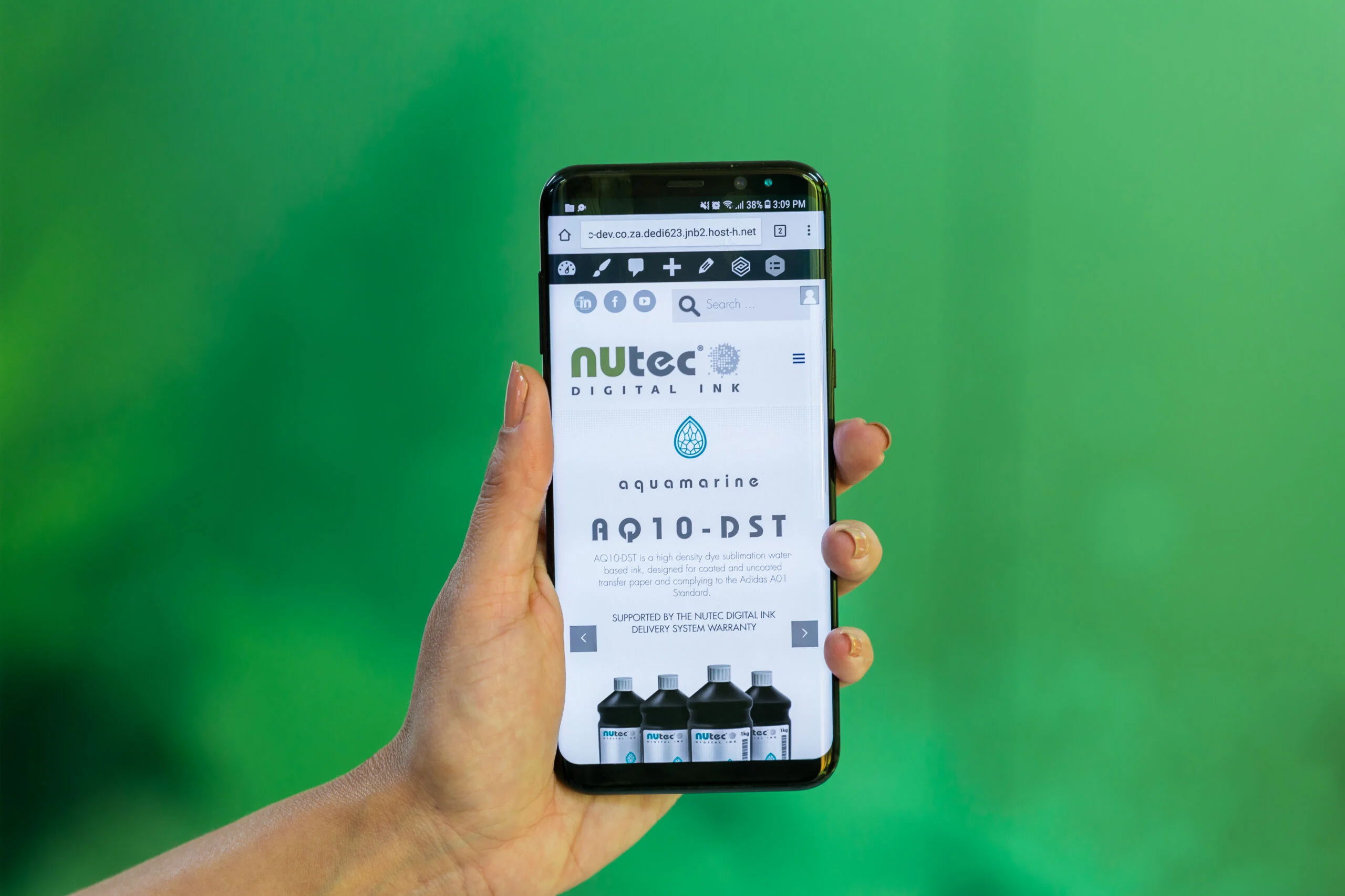 Hand holding a smartphone displaying NUtec Digital Ink's new website with enhanced functionality on a green background, showcasing digital printing ink products.